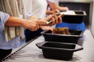 Man Checking Mobile At Airport Security Check